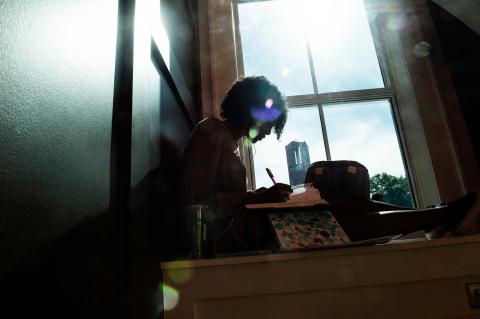 Student studying in the Old Main Academic Center in front of a window